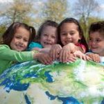 4 children hugging the earth